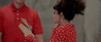 a woman in a red dress standing next to a man in a red shirt