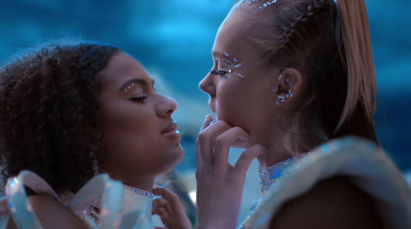 two women in white dresses are looking at each other