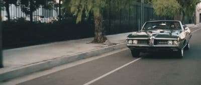 a car driving down a street next to a fence