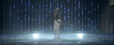 a woman standing in the rain with an umbrella