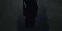 a person standing in a dark room with a light on