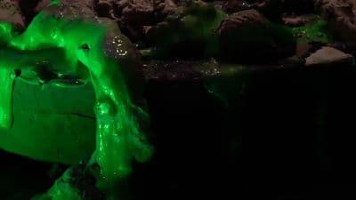 a close up of a green substance on a black surface
