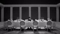 a person sitting at a table with a lot of chairs