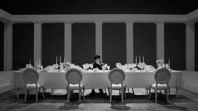 a person sitting at a table with a lot of chairs
