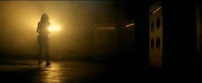 a woman standing in the dark in the dark