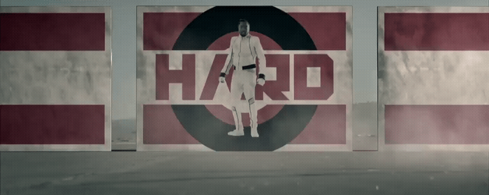 a man standing in front of a wall with the word hard on it