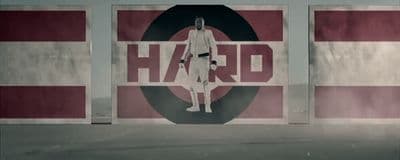 a man standing in front of a wall with the word hard on it