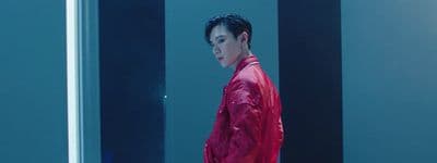 a man in a red jacket standing in a room