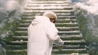 a man in a white coat walking down a set of stairs