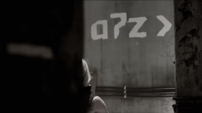 a woman standing in front of a wall with a sign on it
