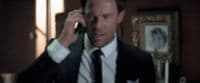 a man in a suit talking on a cell phone