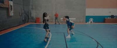 a group of young people playing a game of basketball