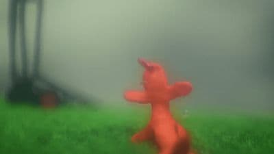a blurry photo of a red teddy bear in a field