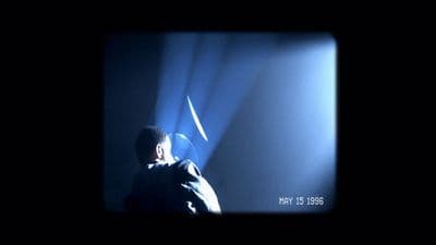 a man standing in front of a blue light