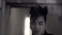 a man with black hair and piercings on his ears