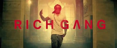 a man standing in front of a doorway with the words rich gang on it