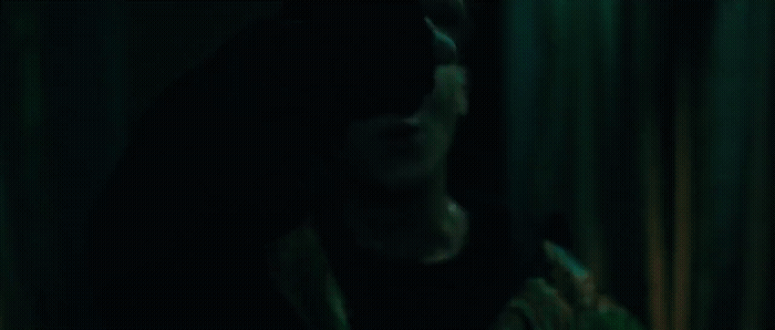 a man in a dark room holding a cell phone
