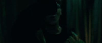 a man in a dark room holding a cell phone