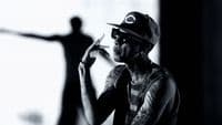 a man in a baseball cap smoking a cigarette