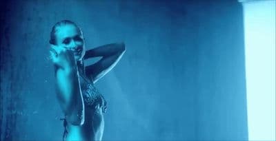 a woman in a bodysuit standing in the water