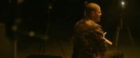 a man sitting on a stool in the dark