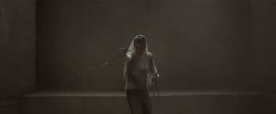 a woman standing in a dark room with a microphone