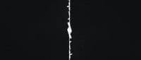 a black and white photo of a crack in a wall