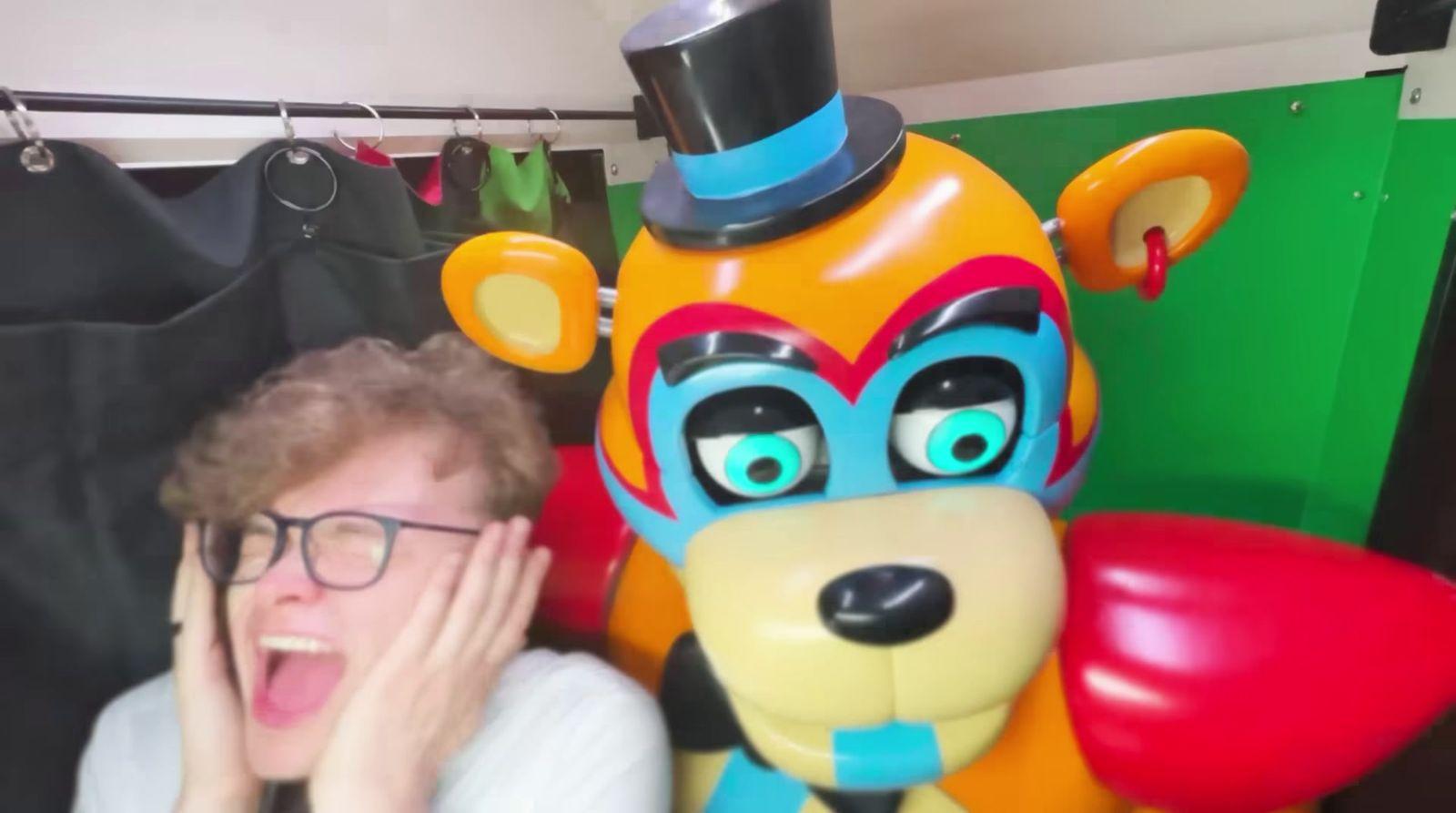 a man standing next to a large stuffed animal