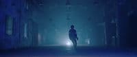 a person standing alone in a dark alley