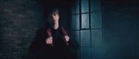 a young man in a dark room holding a cell phone