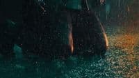 a person standing in the rain with an umbrella