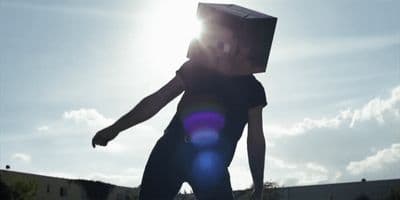 a person with a box on their head on a skateboard