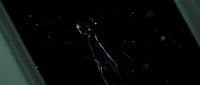 a man standing in the dark with his hands in his pockets