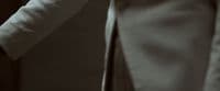 a close up of a person wearing a suit and tie