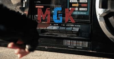 a person holding a cell phone near a machine