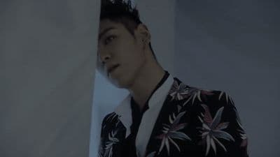 a man with black hair and a floral jacket