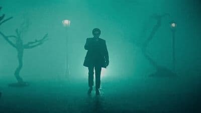 a person standing in a foggy area holding an umbrella