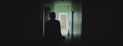 a man standing in a dark hallway in the dark