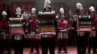 a group of men in uniform playing drums