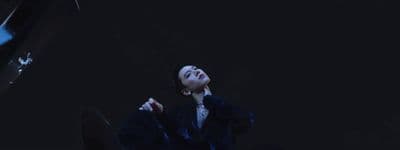 a person sitting on the ground with their eyes closed