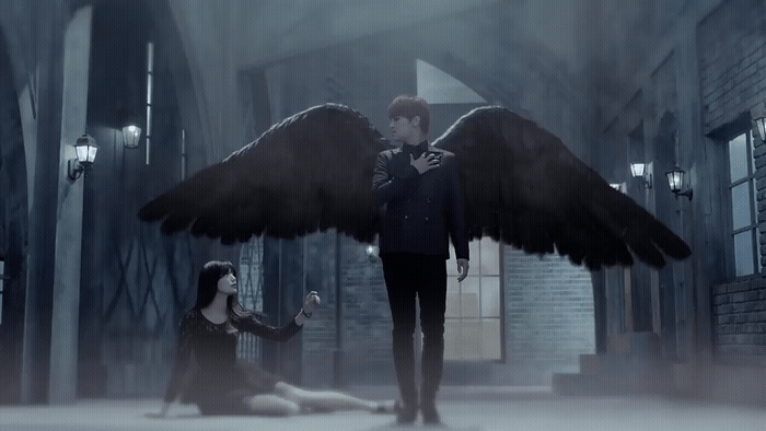 a man standing next to a woman with large wings