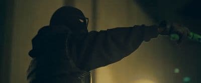 a man in a hoodie holding a skateboard