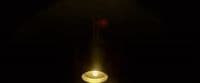a lit candle in a dark room with a black background