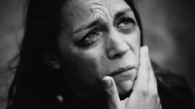 a black and white photo of a woman with her hand on her face
