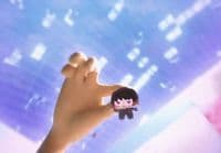 a person holding a small doll in their hand