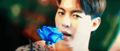 a man holding a blue rose in his hand