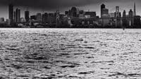 a large body of water with a city in the background