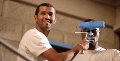 a man holding a paint roller over his face