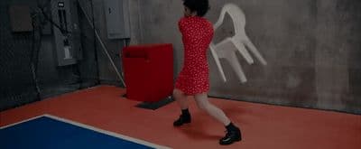 a woman in a red dress is standing in a room