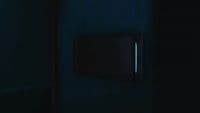 a dark room with a square light switch